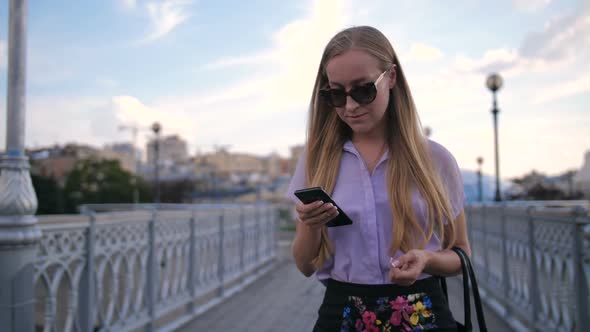 Business Lady in Sunglasses Walking with Phone
