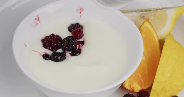 Fresh Blueberries Fall Into a Cup Full of Yogurt