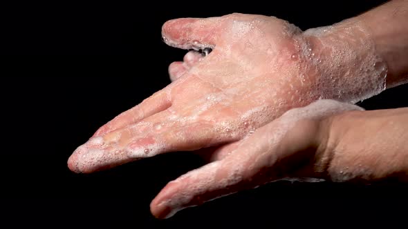 man washes his hands with soap. 