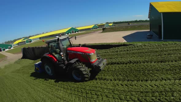 Copter flying around tractors in a silo on a farm