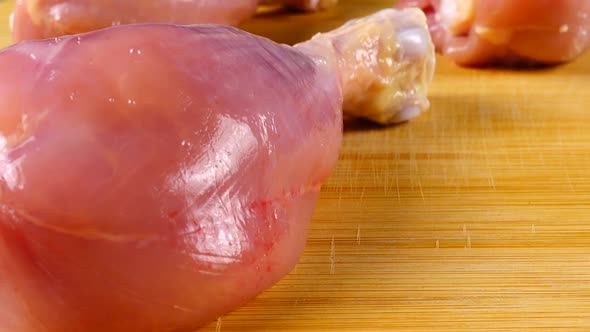 Fresh chicken legs on a cutting board.