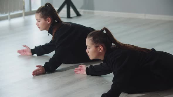 Little Girl Twins Synchronously Practicing Their Dancing in the Studio