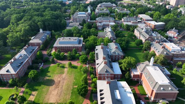 Aerial reveal of Johns Hopkins University college campus. Tilt up reveals Baltimore Maryland region.