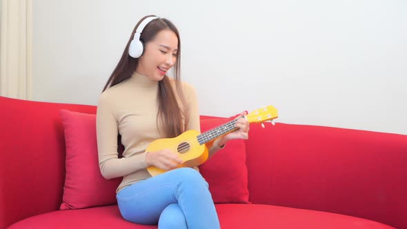 Young asian woman play ukulele