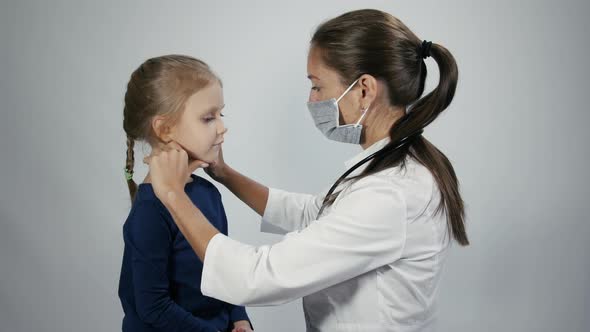 Doctor is palpating lymph node on the neck of little girl