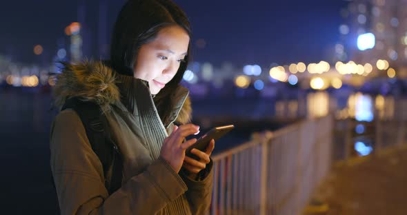 Woman using smart phone at night