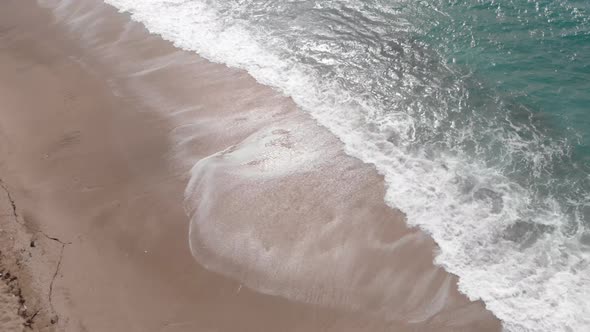 Blue ocean waves splashing and crashing on beach