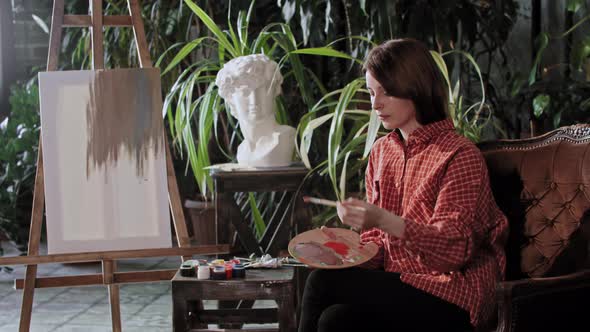 Artist in a Workshop  Young Woman Mixing Colors on a Palette