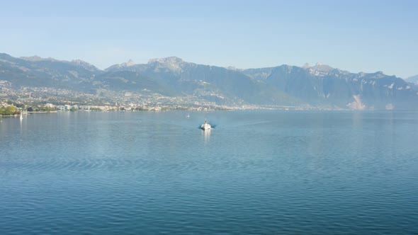 Flying towards Belle-Epoque steam boat on Lake Léman with Vevey, Montreux and the Alps in the backgr