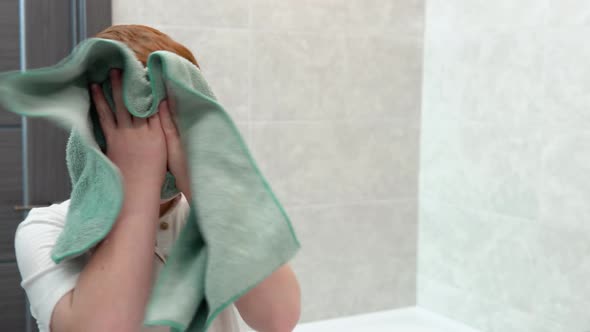 Little Boy Wipes Her Face with a Towel After Shaving