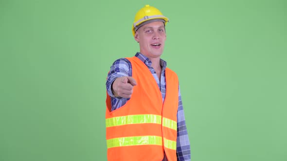 Happy Young Man Construction Worker Pointing at Camera