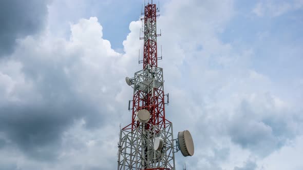 Time lapse of telecommunication tower against sky and clouds in background