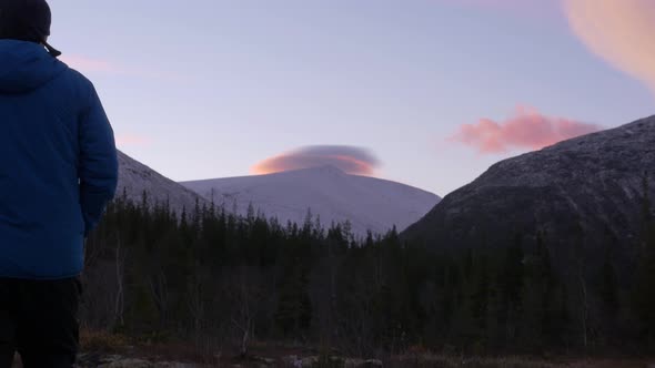 A Man, a Middle-aged Athlete, Meets the Dawn in the Mountains. He Admires the Reflection of the Sun