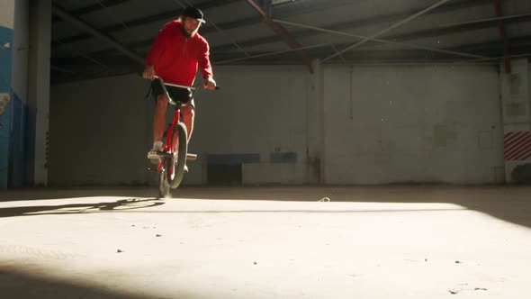 BMX rider in an empty warehouse