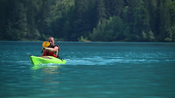 Caucasian Kayaker in His 40s Paddling on the Scenic Weissensee Lake in Slow Motion Footage