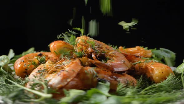 Dill Falls Down Onto Tasty Grilled Shrimps Turning on Table