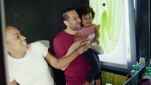 Family brushing their teeth in bathroom