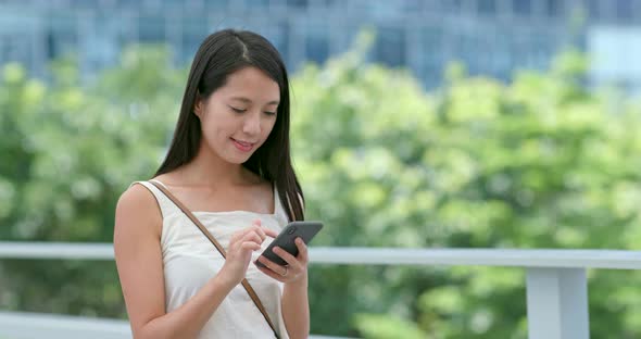 Asian woman use of mobile phone in city