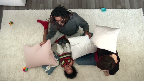 Joyful Family Having Pillow Fight on the Floor