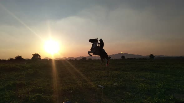 Silhouette of a man Riding a Horse in the Background Sunset