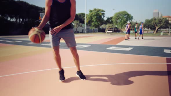 Basketball Player Trains Himself on a Basketball Court with a Ball