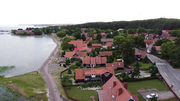 Colorful red rooftops of Nida town in Lithuania, aerial ascending view