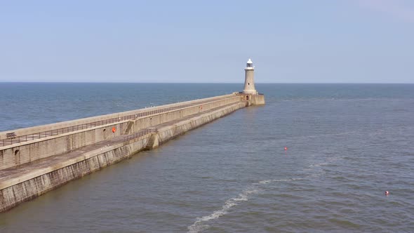 A Lighthouse and Breakwater at the Mouth of a Harbour