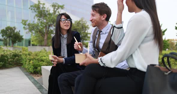 Diverse business people doing lunch break outdoor from office building