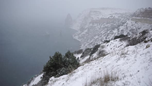 Snow Covered Rocky Cliffs Over Sea