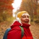 Cheerful Active 50s Woman Walking Along with Headphones Mobile Phone and Backpack Enjoying Listening - VideoHive Item for Sale