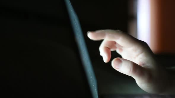 Extreme close up woman hands using touchscreen at night