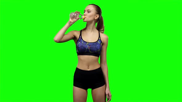 Woman in Sportswear Drinking Water From Bottle. Green Screen