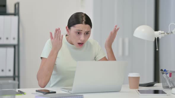 Young Latin Woman with Laptop Reacting To Loss 