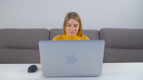 Young adult female doing freelance work on modern notebook computer at home in 4k footage
