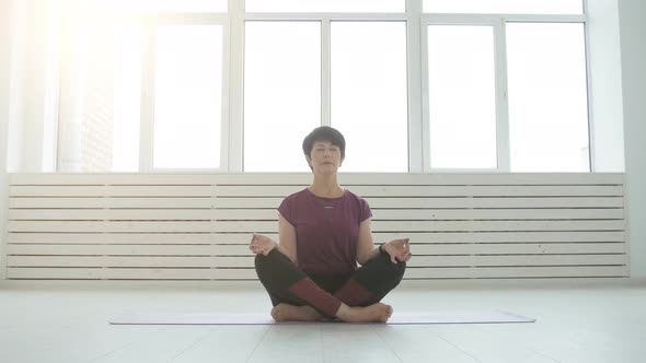 Middle Aged Yogi Attractive Woman Practicing Yoga Indoors