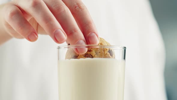 Eating Cookie with Milk in Glass Cup Closeup