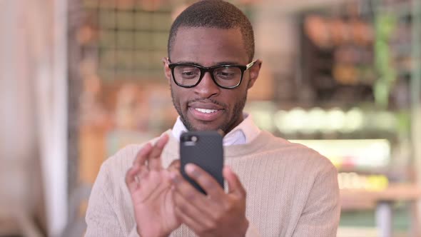 Portrait of Attractive African Man Using Smartphone