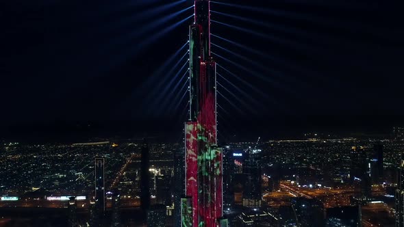 Aerial view of Burj Khalifa Tower with a light show at night in Dubai.