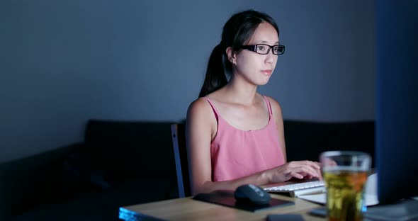 Asian woman working on computer at night 