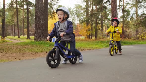 Little Friends Riding Balance Bicycles in Park