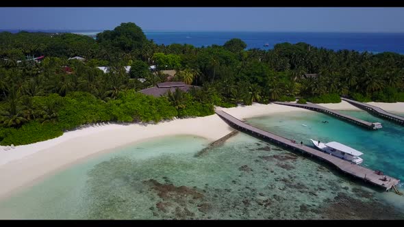 Aerial top down sky of tranquil coast beach voyage by blue green ocean with white sandy background o