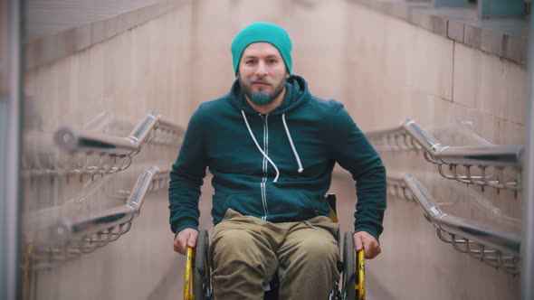 Disabled Man in Wheelchair Smile and Showing Opportunities of His Wheelchair - Moving on the Sides