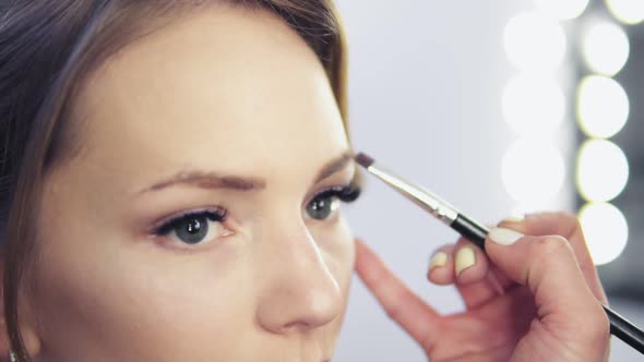 Closeup View of Makeup Artist Applying Eyeshadow on Eyelid Using Makeup Brush