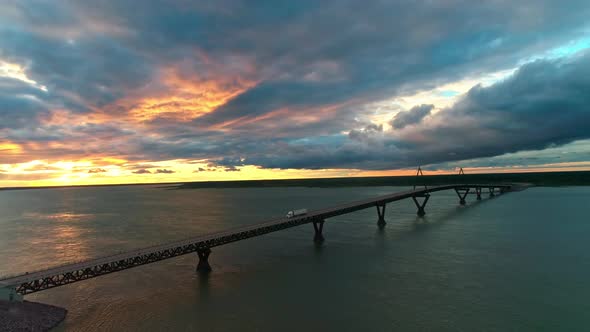 Aerial view of a truck driving over the Deh Cho Bridge at sunset, near Fort Providence Northwest Ter