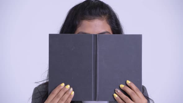 Young Persian Businesswoman Hiding Behind Book and Thinking