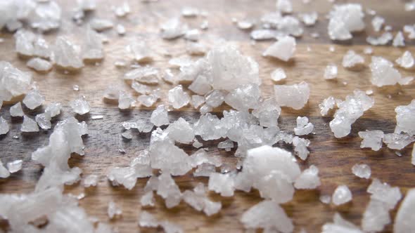 Rough sea salt on a wooden rustic surface. Macro