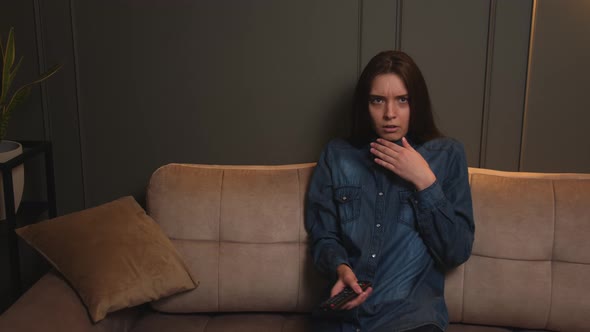 Young Beautiful Woman Sitting at Home Sofa Couch in Living Room Watching Television Scary Horror