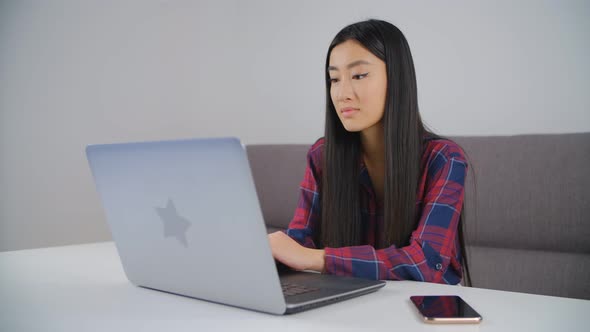 Beautiful Vietnamese girl talking on laptop computer web camera during video call