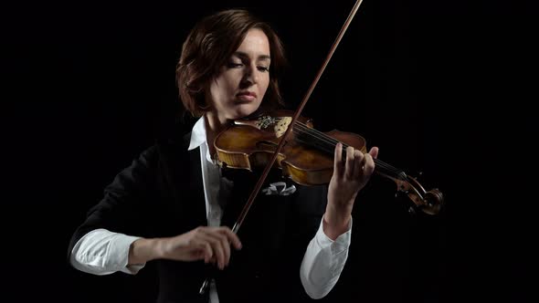 Girl in Play the Violins in a Room. Black Background