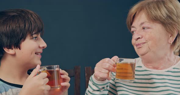 Grandmother and Grandson Teenager Drink Tea Together